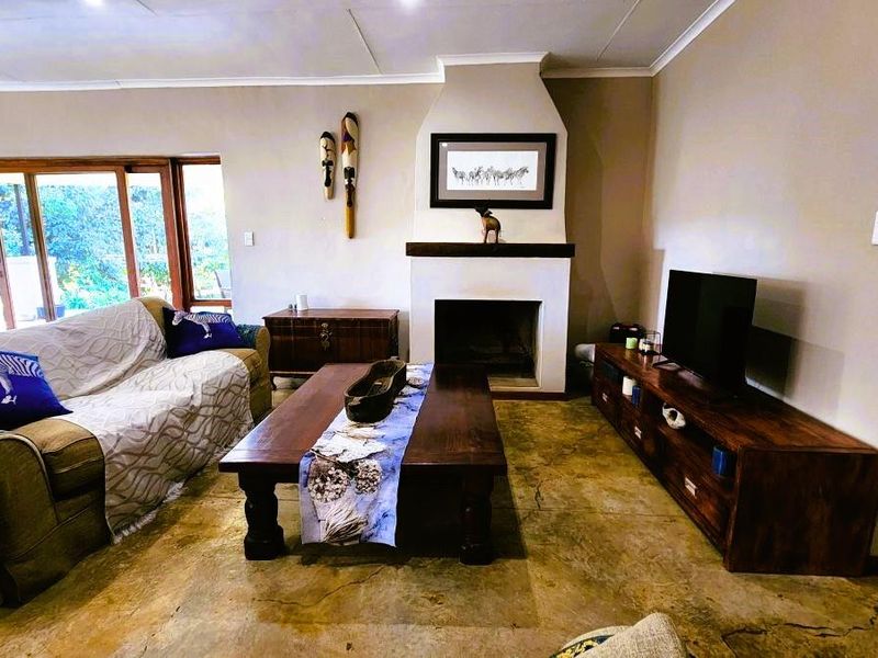 A comfortable living room featuring a central fireplace, polished concrete floors, and large sliding glass doors that provide access to the outdoor area.