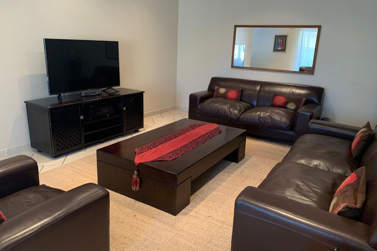 A spacious living room featuring tiled flooring and neutral wall finishes, providing a comfortable and functional area for relaxation.