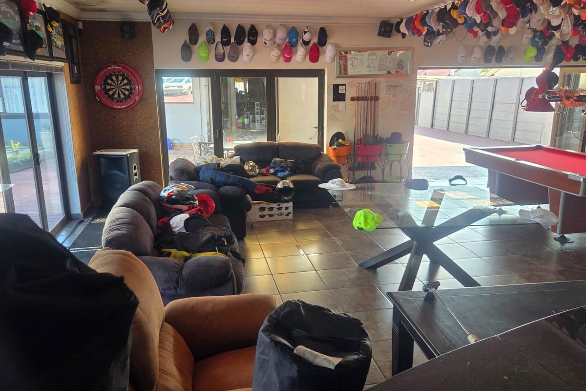Spacious entertainment room featuring tiled flooring, large sliding glass doors providing outdoor access, and ample space for recreational activities.