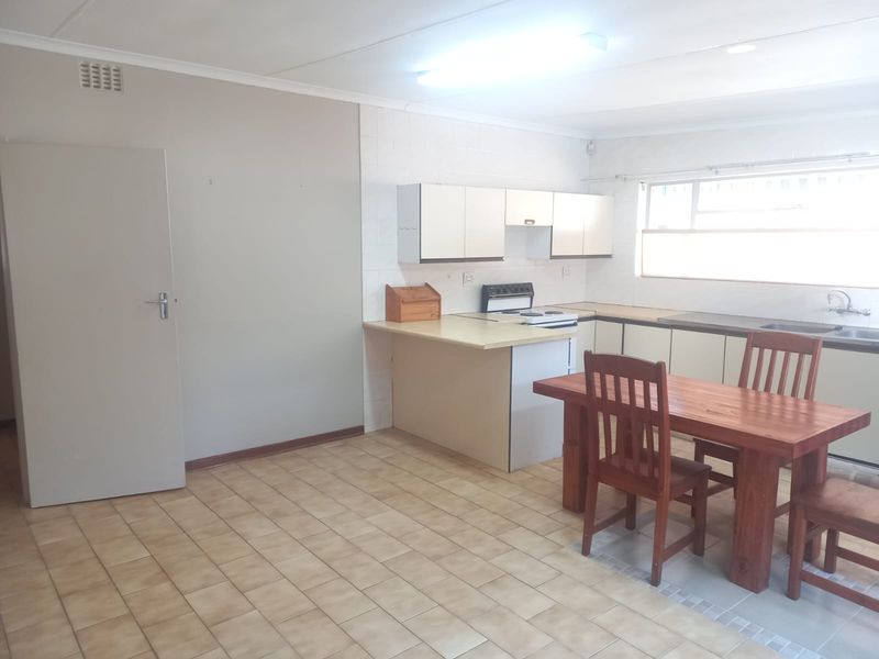 Open plan kitchen and dining area featuring tiled flooring, built-in cabinetry, and a functional layout with a freestanding stove.