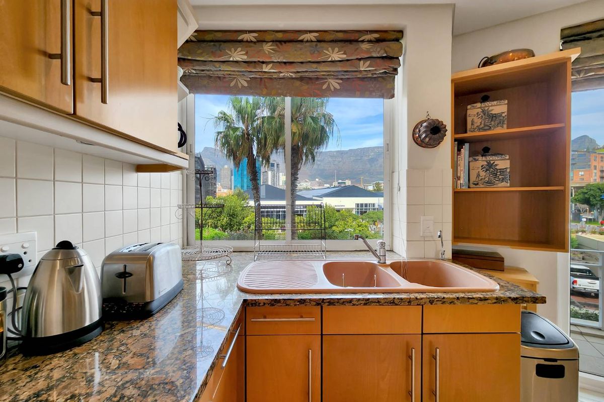 Kitchen area featuring granite countertops, laminate cabinetry, and a double basin sink with a scenic window view.