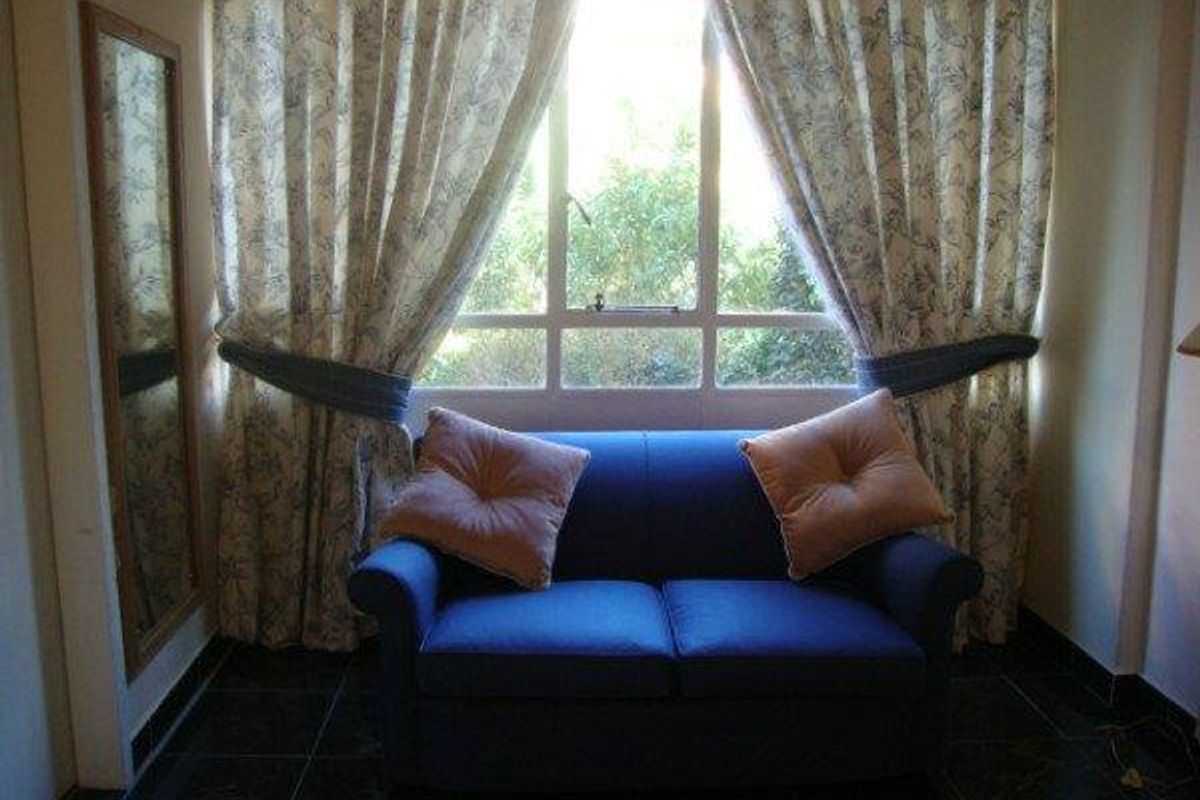 A cozy living area featuring dark tiled flooring and a large window that allows natural light into the space.