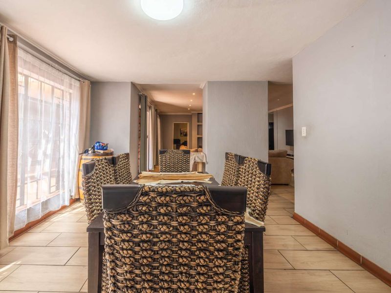 A functional dining area featuring tiled flooring and neutral wall finishes, providing a clear view into the adjacent living space.
