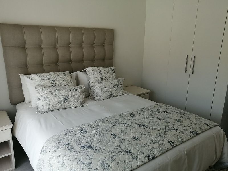 A well-maintained bedroom featuring neutral walls and practical built-in cupboards, offering a clean and comfortable living space.