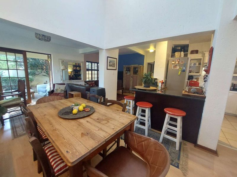 Open-plan living and dining area featuring a breakfast bar, granite countertops, and sliding glass doors leading to an outdoor patio space.