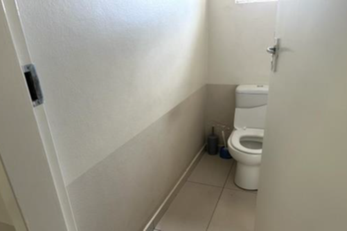 A compact, functional guest toilet featuring tiled flooring and neutral wall finishes.