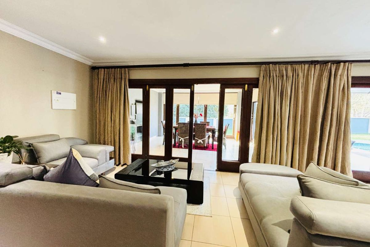 Spacious living area featuring large wooden sliding doors that open onto a covered patio, creating a seamless transition between indoor and outdoor living spaces.