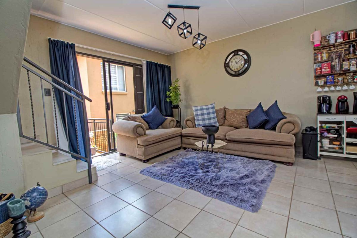 A living room featuring tiled flooring, a staircase with a metal railing, and sliding glass doors leading to an outdoor patio area.