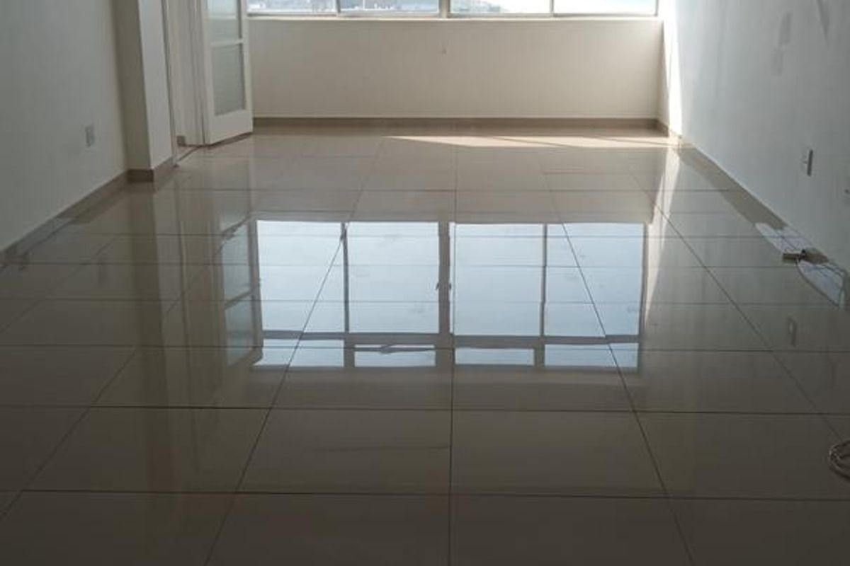 Spacious, empty living area featuring polished tiled flooring, a ceiling fan, and large windows providing natural light and an urban view.