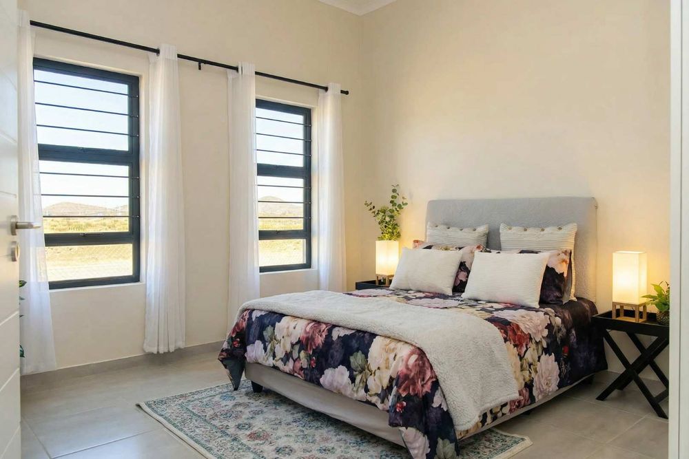 A spacious main bedroom with built-in cupboards and ensuite bathroom.