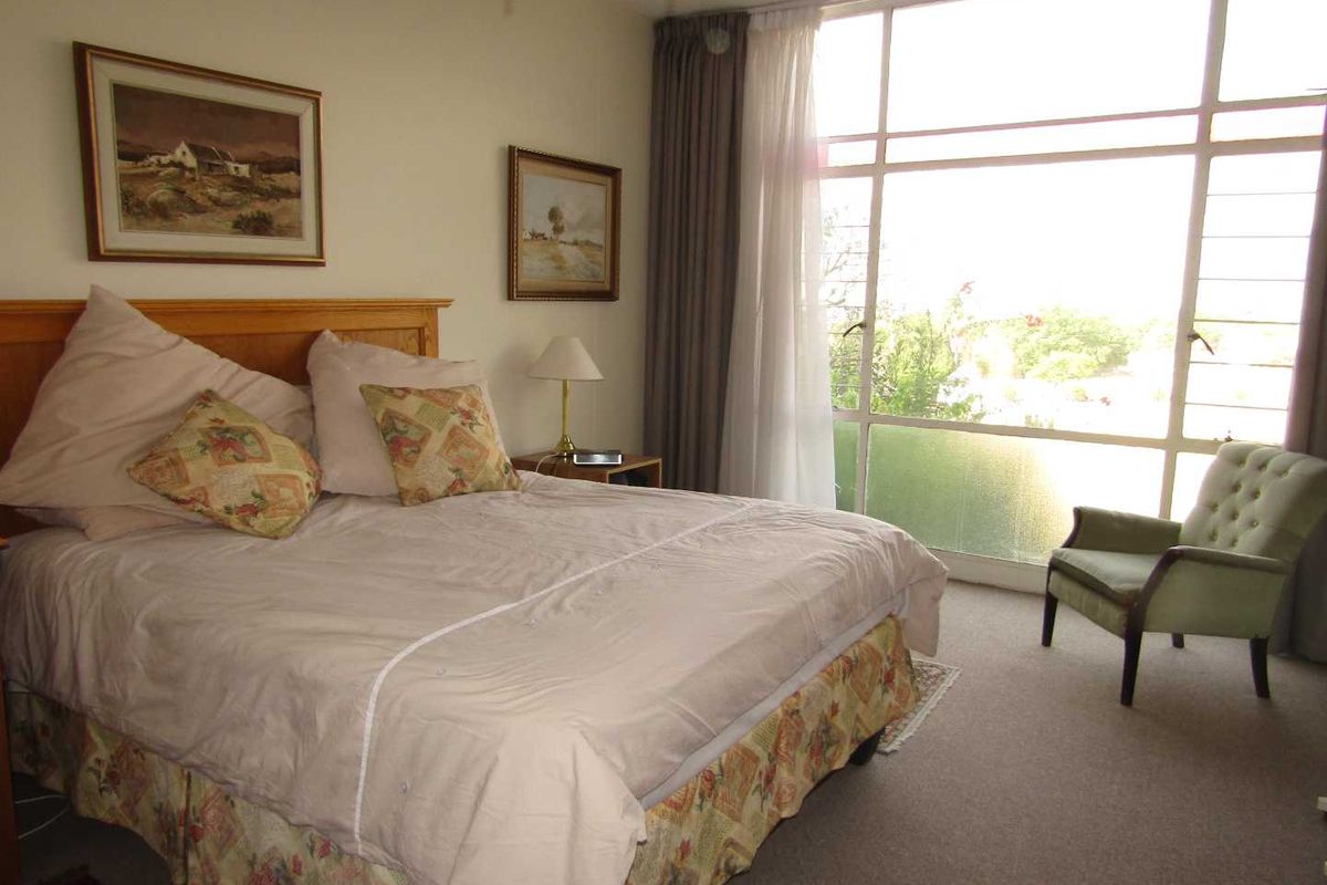 A bedroom featuring large floor-to-ceiling windows that provide ample natural light and views of the surrounding area.