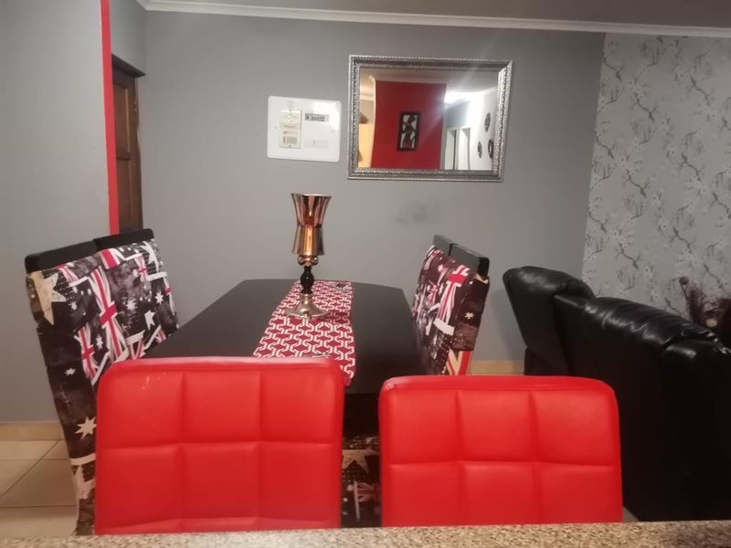 A dining area featuring tiled flooring and coving, with an integrated electrical distribution board visible on the wall.