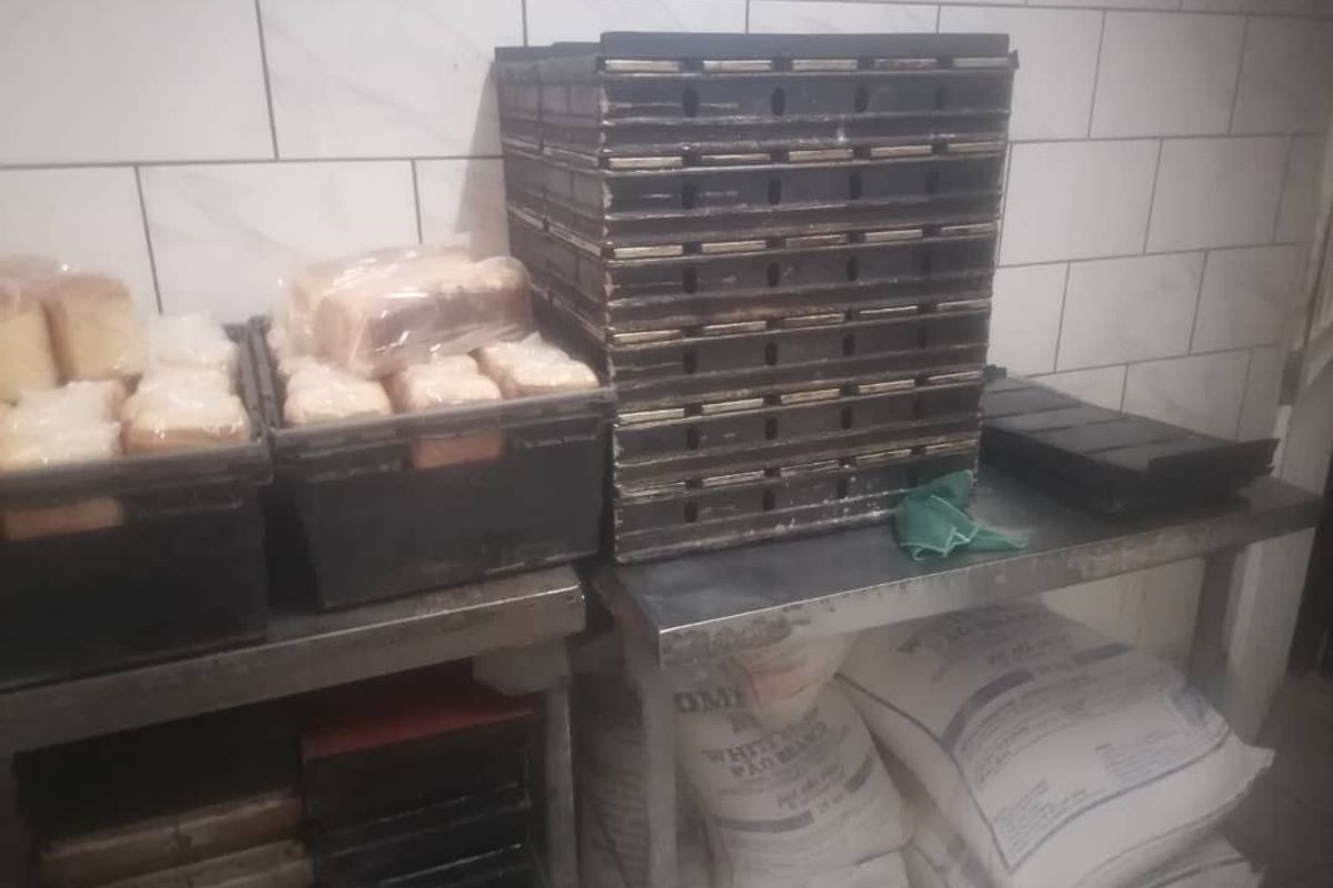 A commercial kitchen prep area featuring stainless steel work surfaces and subway tile wall finishes.