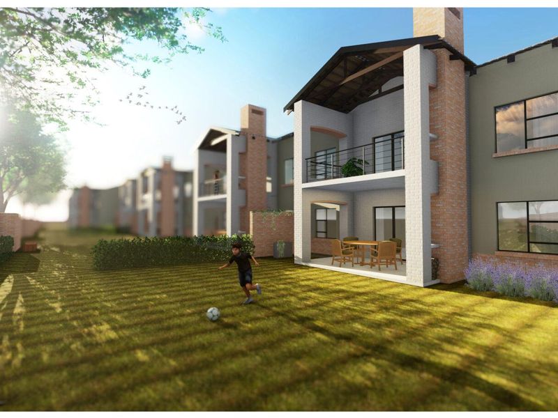A rear view of a townhouse complex featuring brick facades, chimneys, and private balconies overlooking a shared garden area.