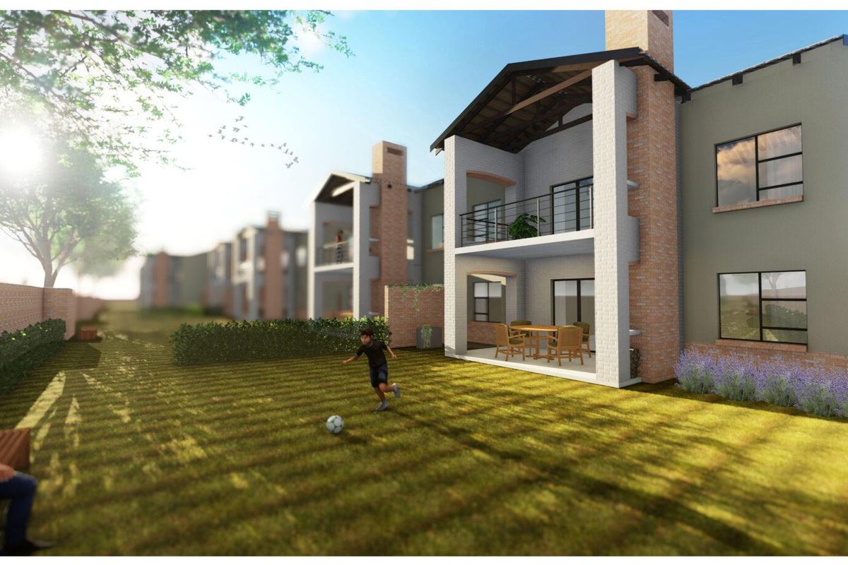 A rear view of a townhouse complex featuring brick facades, chimneys, and private balconies overlooking a shared garden area.