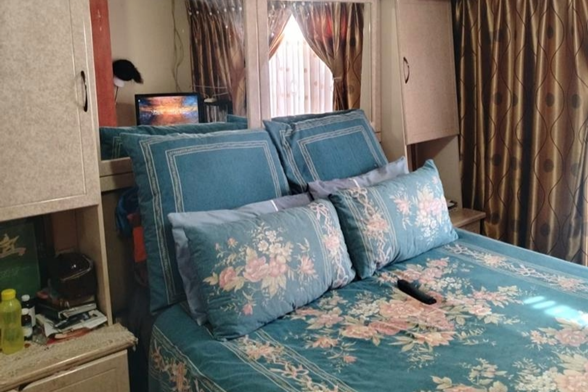 A bedroom featuring built-in cabinetry with integrated mirror panels and bedside storage units.