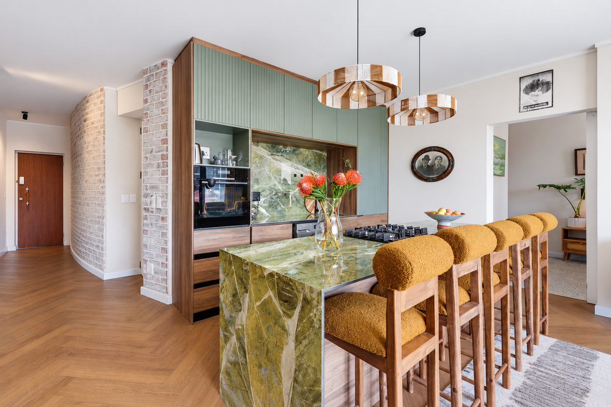 Modern kitchen featuring a striking green stone island, integrated appliances, custom cabinetry, and elegant herringbone flooring, creating a sophisticated and functional culinary space.