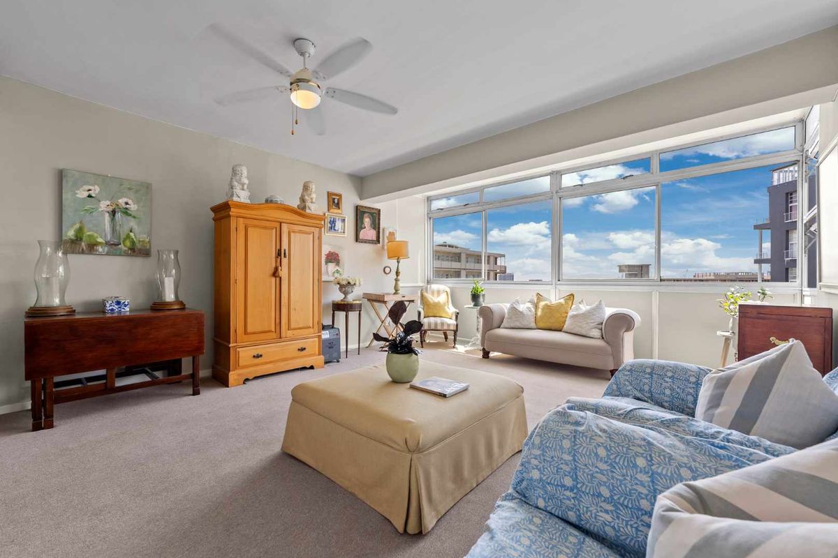 A bright and spacious living room featuring large windows that provide ample natural light and expansive views.