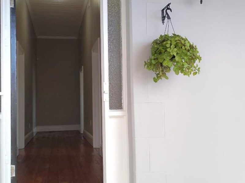 A welcoming front entrance featuring a tiled porch, timber flooring inside, and classic architectural details including a transom and sidelight window.