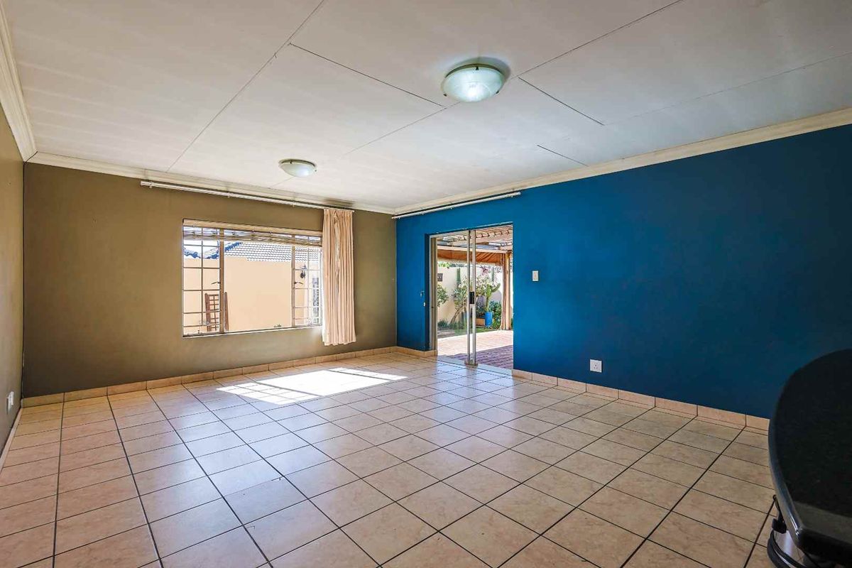 Spacious living area featuring tiled flooring, large windows for natural light, and sliding glass doors providing direct access to the outdoor patio.
