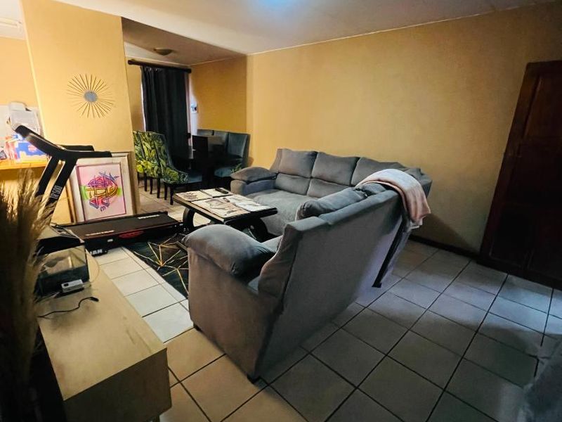 Open plan living area featuring ceramic floor tiles and neutral wall tones, offering a functional space ready for modernization and aesthetic updates.