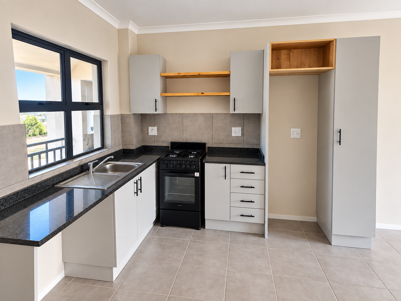 A modern, clean kitchen featuring light grey cabinetry, granite countertops, a stainless steel sink, and a freestanding stove with tiled flooring and backsplash.