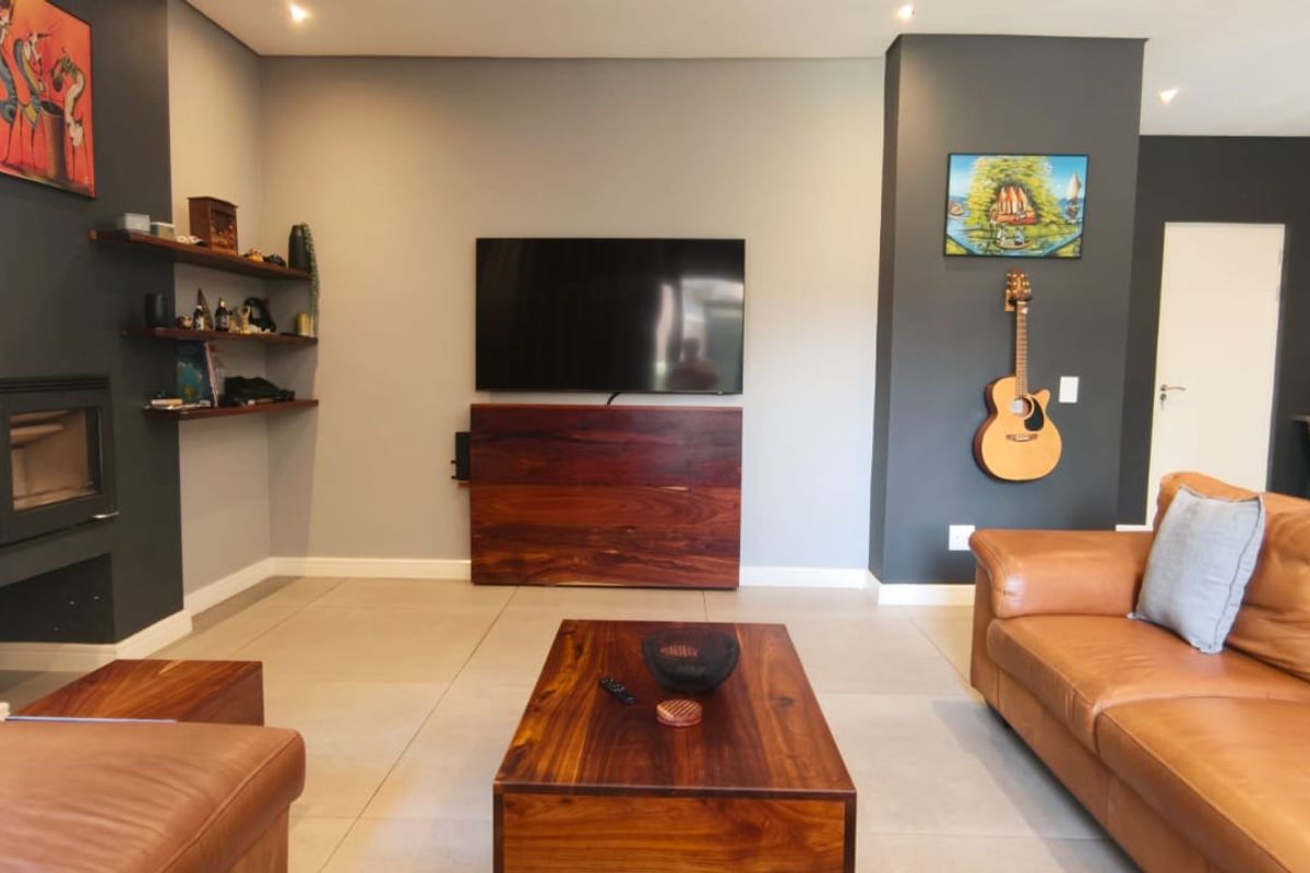 Modern living room featuring tiled flooring, a built-in fireplace, recessed lighting, and a neutral color palette with dark accent walls.