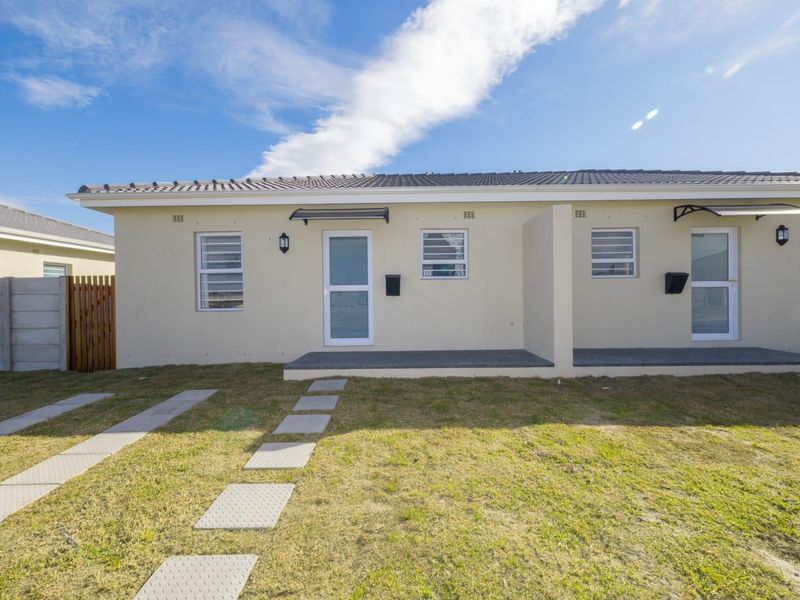 Front view of a modern residential unit featuring a tiled roof, paved walkway, and concrete driveway with well-maintained exterior finishes.