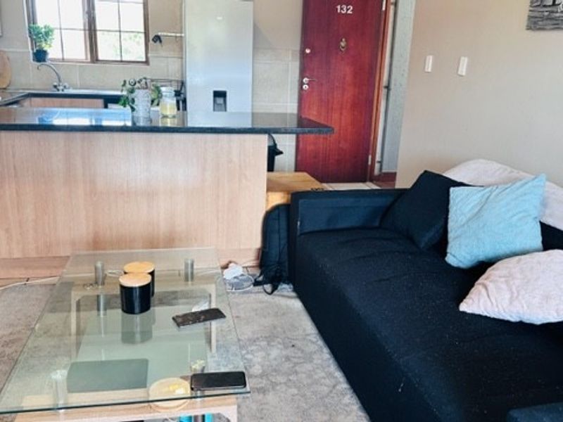 Open plan living area featuring a kitchen with granite countertops and tiled flooring, seamlessly connected to the main living space.