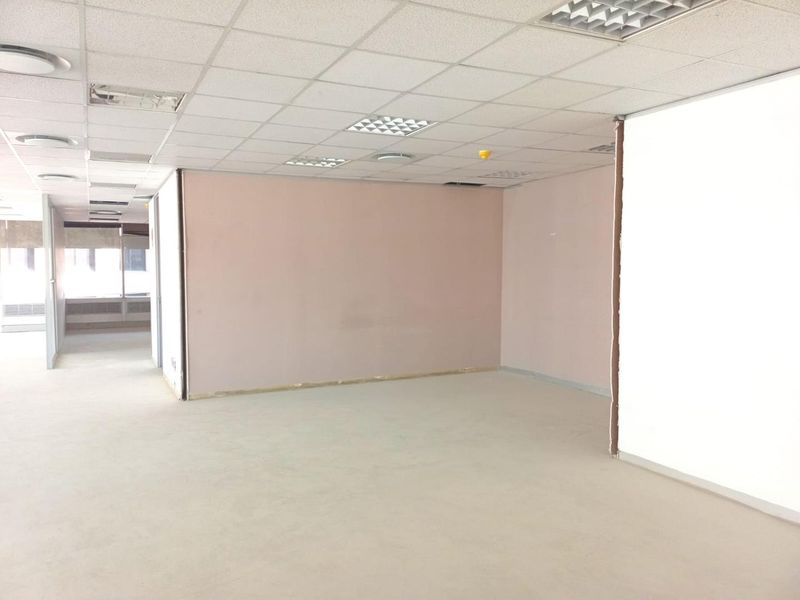 An empty, open-plan office space featuring a suspended ceiling with recessed lighting and neutral wall finishes, ready for custom fit-out.