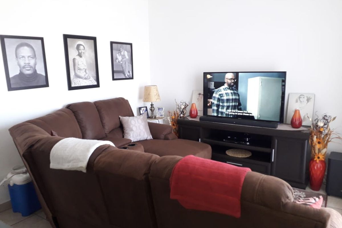A comfortable living room area featuring tiled flooring and neutral wall finishes, providing a functional space for relaxation and entertainment.