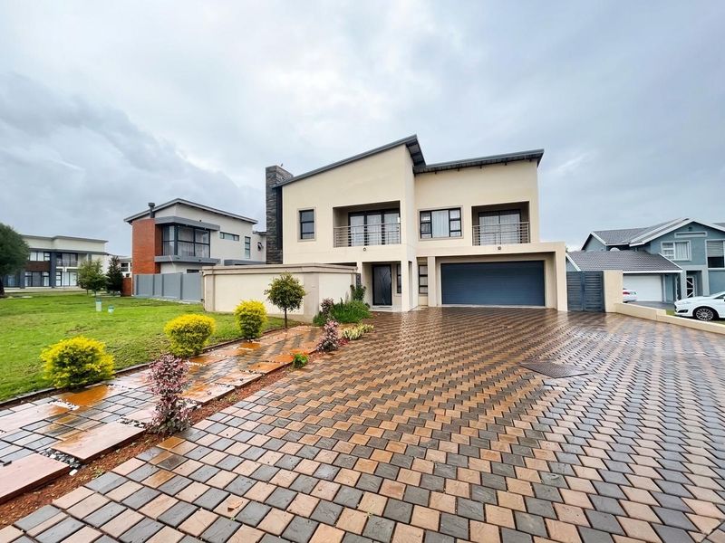 Modern double-storey residential property featuring a paved driveway, double garage, and upper-level balcony with contemporary architectural finishes.