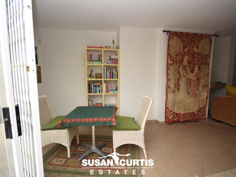 A living area featuring tiled flooring and a security gate, providing access to the outdoor space.