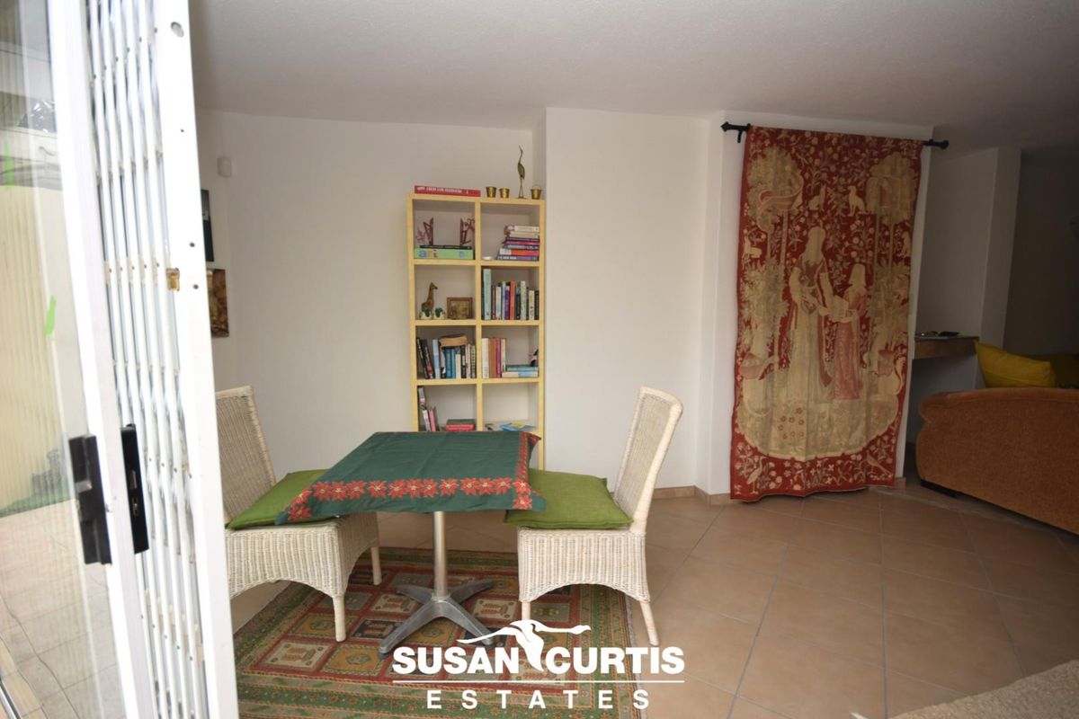 A living area featuring tiled flooring and a security gate, providing access to the outdoor space.