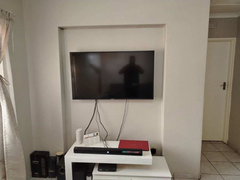 A living room area featuring a recessed wall niche for media equipment and tiled flooring throughout.