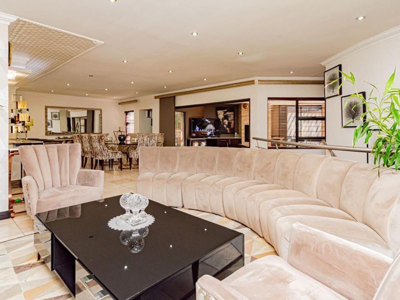 Spacious open-plan living and dining area featuring tiled flooring, recessed downlighting, and a decorative ceiling feature, creating a bright and inviting atmosphere.