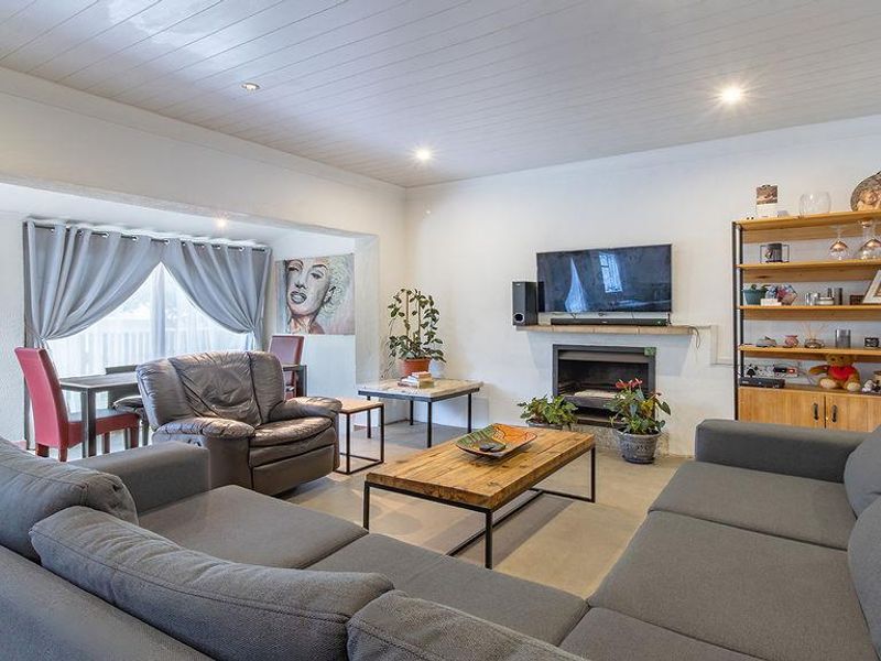 Spacious living room featuring a fireplace, recessed lighting, and a classic tongue and groove ceiling, creating a comfortable and inviting atmosphere.