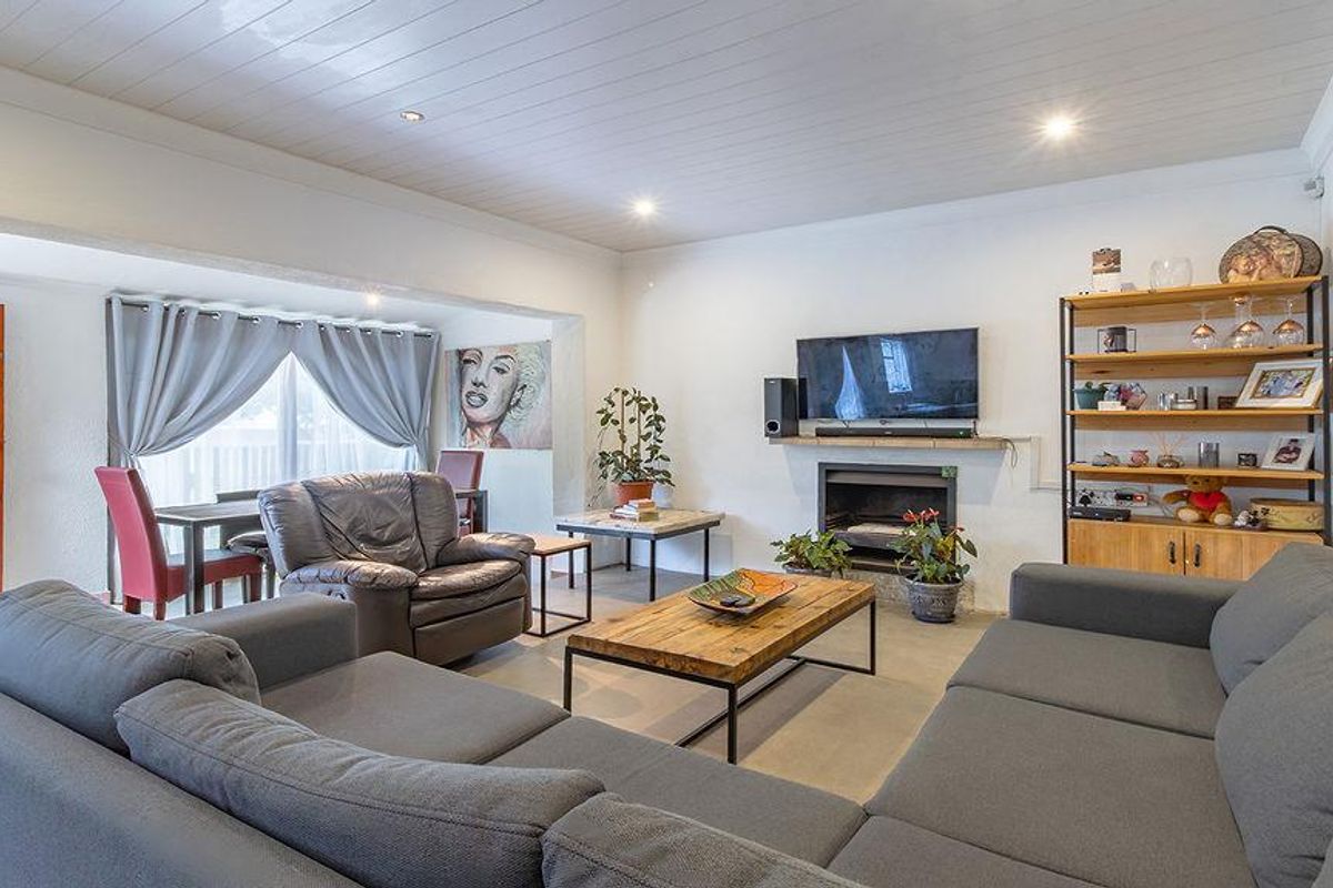 Spacious living room featuring a fireplace, recessed lighting, and a classic tongue and groove ceiling, creating a comfortable and inviting atmosphere.