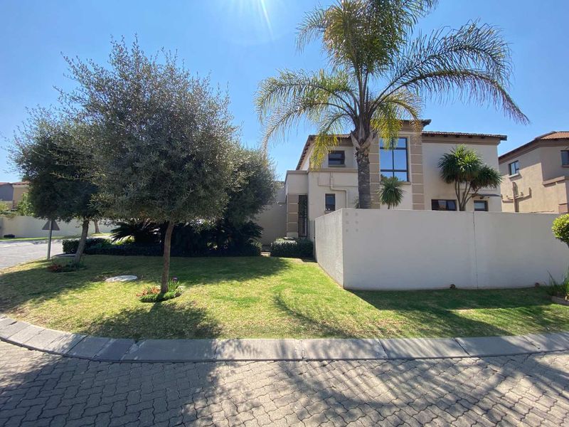A well-maintained double-storey residential property featuring a landscaped front garden, boundary wall, and paved driveway access.