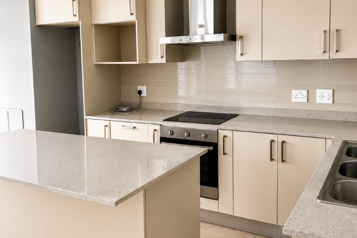 Modern kitchen featuring neutral cabinetry, stone countertops, integrated oven and hob, stainless steel extractor fan, and tiled flooring in a clean, open layout.