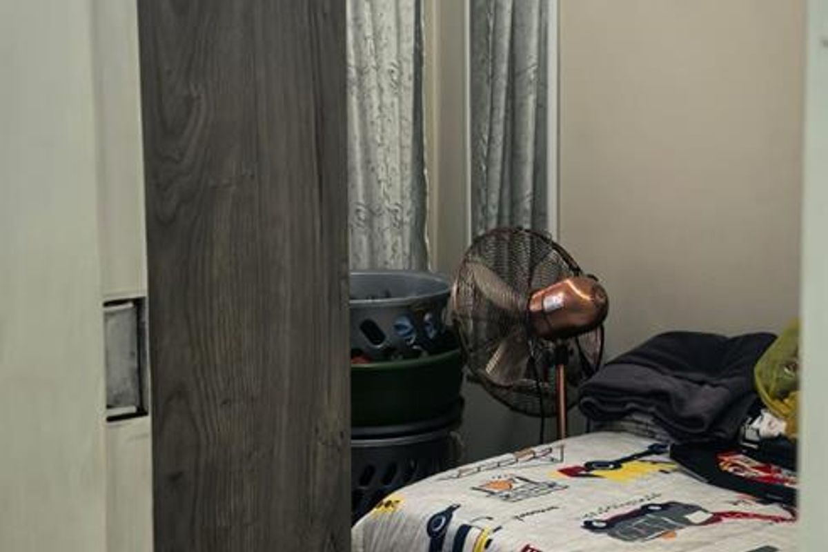 A compact bedroom featuring tiled flooring and crown molding, viewed through a doorway.