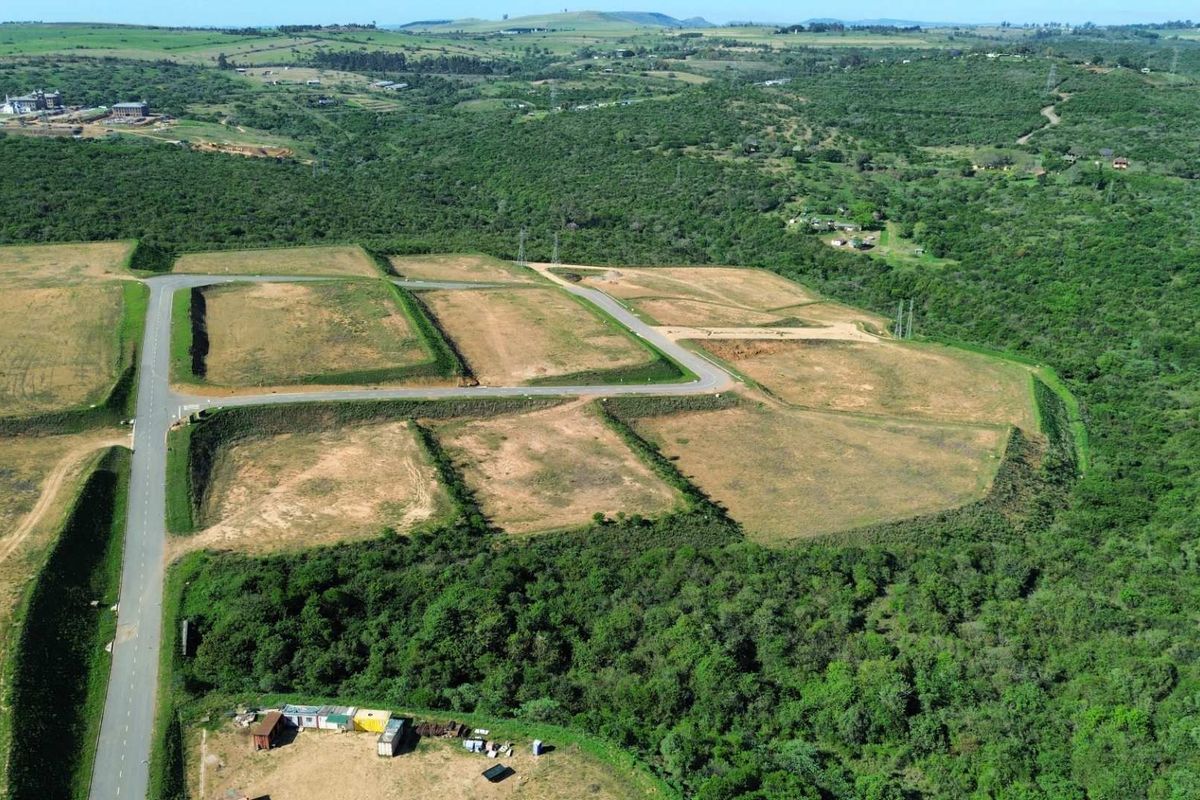 Aerial view of a developed industrial land parcel featuring paved access roads and cleared plots surrounded by natural vegetation.