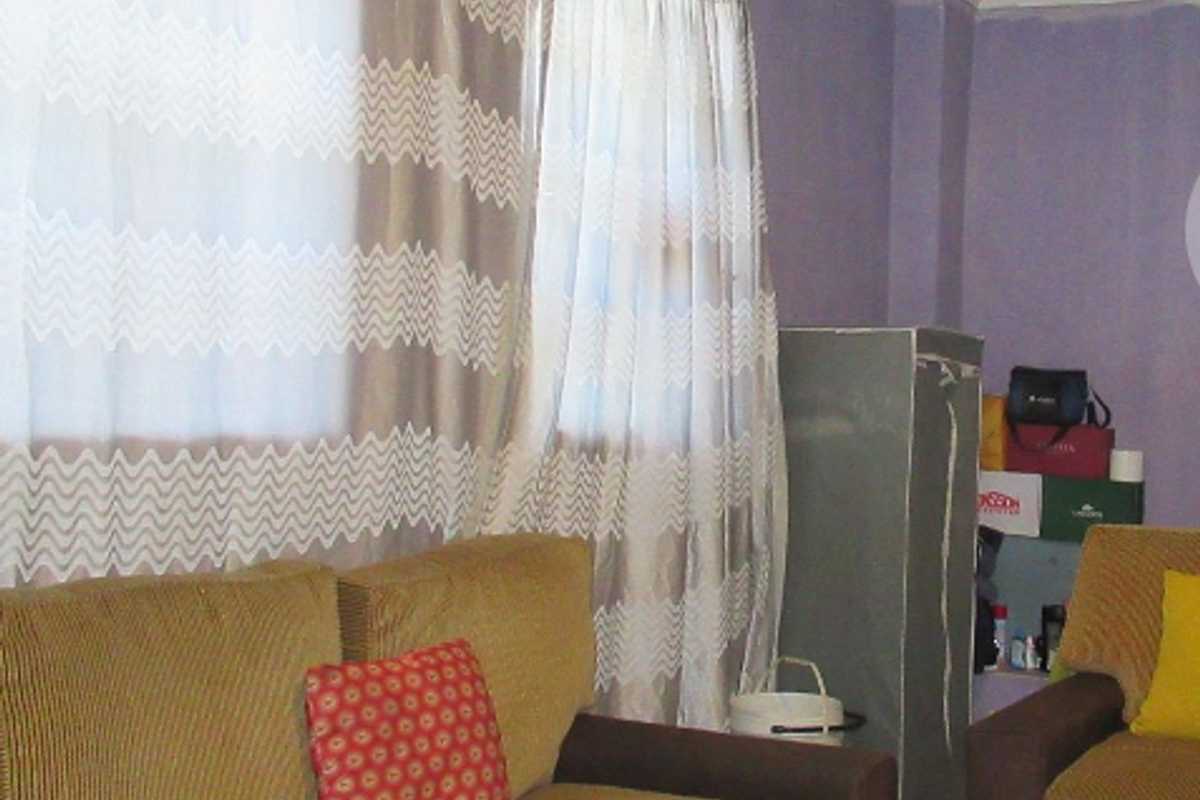 A living room area featuring purple painted walls and window curtains.