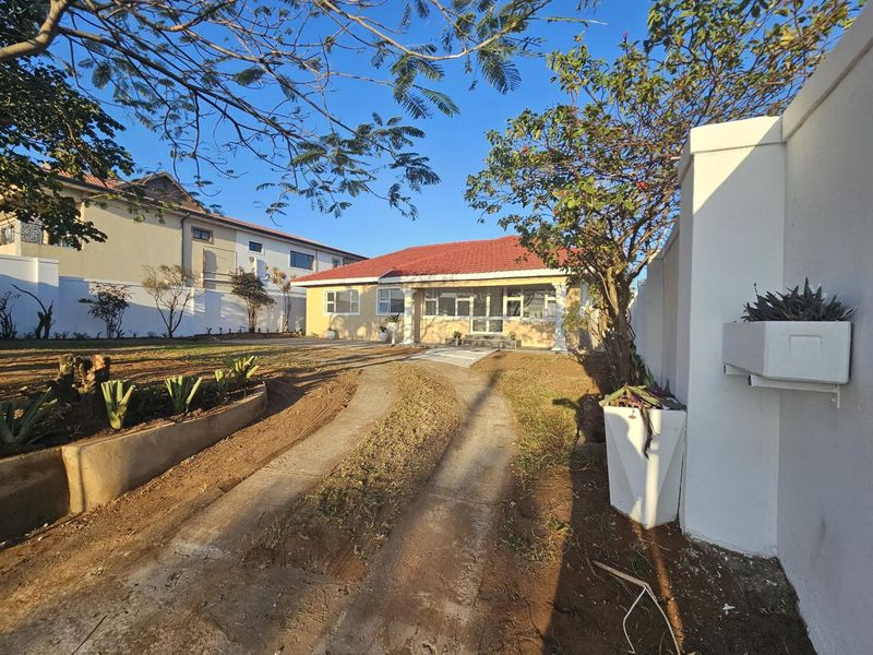 Front exterior view of a single-story house featuring a tiled roof, covered entrance, and a driveway leading to the property.