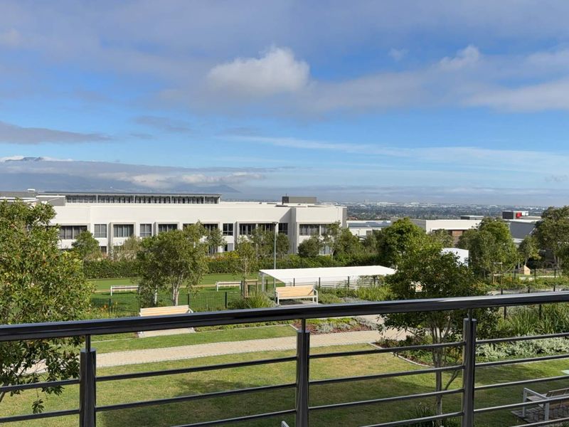 Elevated view overlooking the retirement village landscaped gardens and surrounding estate grounds, featuring a modern stainless steel balustrade.