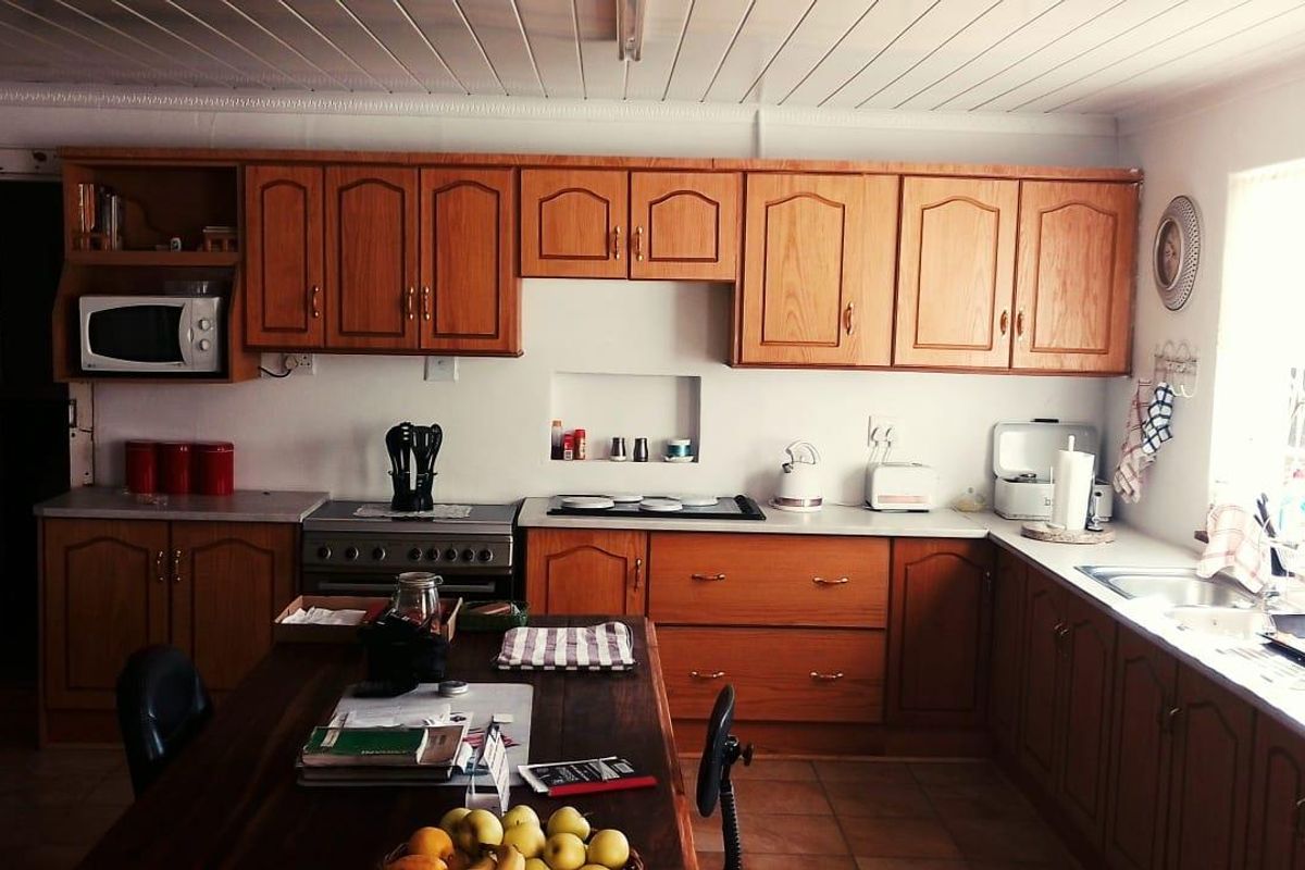 A functional kitchen featuring wooden cabinetry, built-in stove and oven, and tiled flooring, offering a practical layout for daily meal preparation.