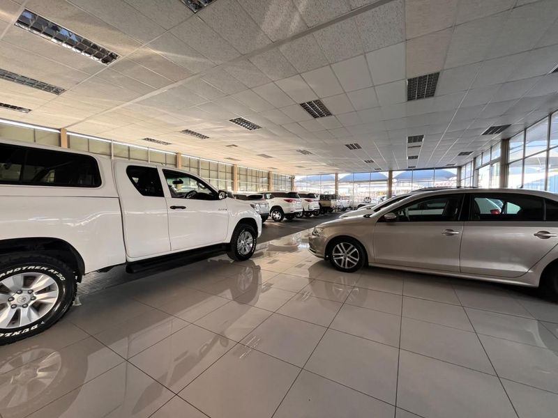Spacious retail showroom featuring high-gloss tiled flooring, a suspended ceiling with integrated lighting, and extensive glass frontage for optimal natural light and visibility.