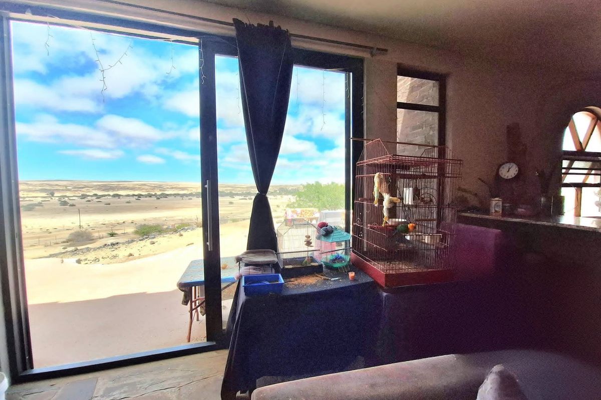 Living area featuring stone flooring and large sliding glass doors that provide expansive views of the surrounding landscape.