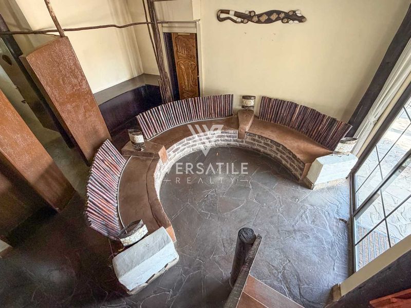 A unique living area featuring a built-in curved stone bench, slate flooring, and large sliding glass doors providing natural light.