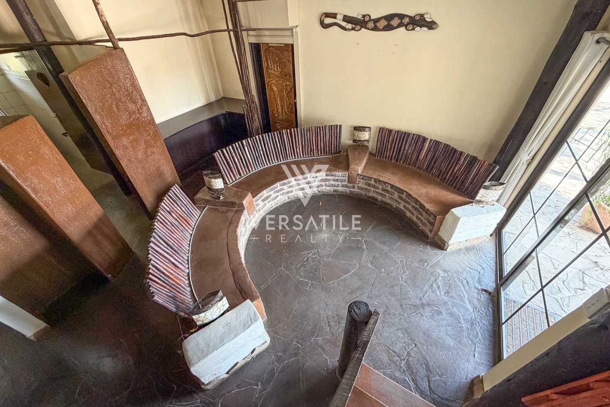 A unique living area featuring a built-in curved stone bench, slate flooring, and large sliding glass doors providing natural light.